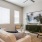 Spacious and well lit living room with wood flooring, large windows and open access to the kitchen