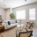 Spacious and well lit living room with wood flooring, large windows and open access to the kitchen