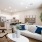 Spacious and well lit living room with wood flooring, large windows and open access to the kitchen