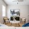 Spacious and well lit living room with wood flooring, large windows and open access to the kitchen