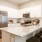 Spacious and well lit kitchen with wood flooring and stainless steel appliances