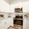 Spacious and well lit kitchen with wood flooring and stainless steel appliances