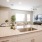 Spacious and well lit kitchen with wood flooring and stainless steel appliances