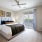 Large well lit bedroom with plush carpets and large windows 