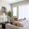 Spacious and well lit living room with wood flooring, large windows and open access to the kitchen