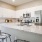 Spacious and well lit kitchen with wood flooring and stainless steel appliances