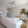Spacious and well lit living room with wood flooring, large windows and open access to the kitchen