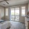 Large well lit bedroom with plush carpets and large windows 