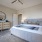 Large well lit bedroom with plush carpets and large windows 